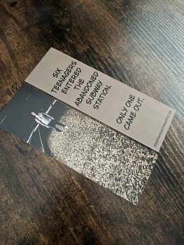 Bookmark: on one side is a photograph of a lone person in a subway tunnel, on the other side are the words "Six teenagers entered the abandoned subway station. Only one came out."